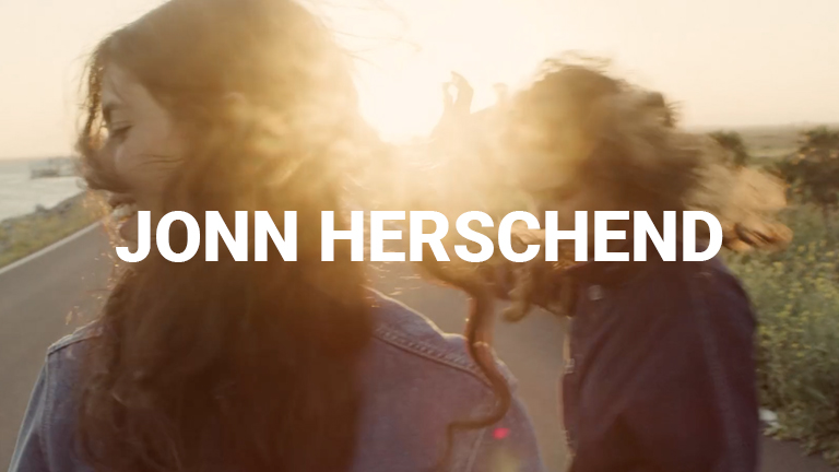 A still from director Jonn Herschend's reel. His name is written in text at the center of the image